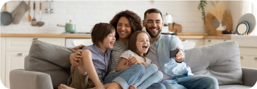 Una familia sonriente sentados en un sofá